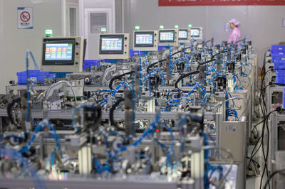 8月14日,在贛州訊康電子科技,工作人員從T1-T2全自動穿環(huán)機旁走過,該機器生產(chǎn)磁性元器件。新華社記者 才揚 攝